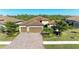 Three-car garage home with paver driveway and lush landscaping at 20710 Saluti Pl, Venice, FL 34293