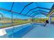 Covered patio area with pool and spa, screened enclosure, and lake view at 20710 Saluti Pl, Venice, FL 34293