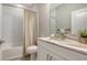 Bright bathroom featuring a tub with a shower curtain, white vanity, and a granite countertop at 2090 Sylvan Lea Dr, Sarasota, FL 34240