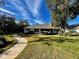 Home's backyard features a large deck, lush lawn, and a stone pathway at 2704 Barret Ave, Plant City, FL 33566