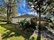 Side view of house with mature trees and landscaping at 2704 Barret Ave, Plant City, FL 33566