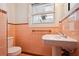 Retro bathroom with pink tile and updated toilet at 349 Scott Ave, Sarasota, FL 34243