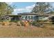 Mid-century modern home with gray siding and a lush front yard at 349 Scott Ave, Sarasota, FL 34243