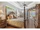 Main bedroom with a large four poster bed, hardwood floors and access to the patio at 3861 Royal Hammock Blvd, Sarasota, FL 34240