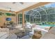 Covered lanai with pool access, seating and dining area at 3861 Royal Hammock Blvd, Sarasota, FL 34240