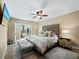 Main bedroom with king-size bed, ensuite bathroom access, and a ceiling fan at 4215 Gulf Of Mexico Dr # 103, Longboat Key, FL 34228