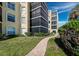 A brick pathway winds through a landscaped area, showcasing the building's exterior at 4215 Gulf Of Mexico Dr # 103, Longboat Key, FL 34228