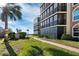Brick pathway meanders through a lush green lawn towards a multi-story building at 4215 Gulf Of Mexico Dr # 103, Longboat Key, FL 34228