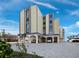 Tan three-story building with covered parking and ocean views at 4215 Gulf Of Mexico Dr # 103, Longboat Key, FL 34228