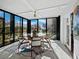 Sunroom dining area with glass doors and ocean view at 4215 Gulf Of Mexico Dr # 103, Longboat Key, FL 34228