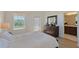 Bright bedroom with a white bed, dresser, and ensuite bathroom at 4755 Woodbrook Dr, Sarasota, FL 34243
