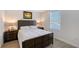 Bright bedroom with a dark wood bed frame, light bedding, and hardwood floors at 4755 Woodbrook Dr, Sarasota, FL 34243
