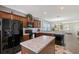 Modern kitchen with granite counters, dark wood cabinets, and black appliances at 4755 Woodbrook Dr, Sarasota, FL 34243