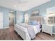 Bright and airy main bedroom with light blue walls, a king-size bed and an ensuite bathroom at 4831 Boston Common Gln, Bradenton, FL 34211