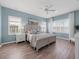 Serene main bedroom with light blue walls, a king-size bed, and wood-look floors at 4831 Boston Common Gln, Bradenton, FL 34211