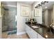 Modern bathroom with dark granite vanity and large walk-in shower at 540 N Tamiami Trl # 702, Sarasota, FL 34236