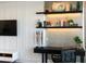 Modern home office with built-in shelving and a large TV at 540 N Tamiami Trl # 702, Sarasota, FL 34236