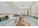 White kitchen features teal countertops, breakfast nook, and plenty of cabinet space at 554 Fallbrook Dr, Venice, FL 34292