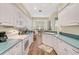 Galley kitchen with white cabinets and teal countertops at 554 Fallbrook Dr, Venice, FL 34292