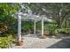 White wooden pergola in a lush garden setting at 554 Fallbrook Dr, Venice, FL 34292