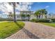 Two-story house with paver driveway, lush landscaping, and palm trees at 634 Key Royale Dr, Holmes Beach, FL 34217