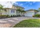 Two-story house featuring a white exterior, paver driveway, and tropical landscaping at 634 Key Royale Dr, Holmes Beach, FL 34217