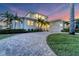 Two-story home with a paved driveway and landscaped yard at sunset at 634 Key Royale Dr, Holmes Beach, FL 34217