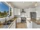 Modern kitchen with white cabinets, granite countertops, and stainless steel appliances at 634 Key Royale Dr, Holmes Beach, FL 34217
