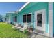 Light teal colored building exterior with white door and two chairs at 6424 Midnight Pass Rd # 12A, Sarasota, FL 34242
