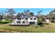 Exterior view of a two-story home with a balcony, manicured lawn, and mature trees at 6706 88Th E St, Bradenton, FL 34202