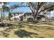 Two-story house with white exterior, dark gray accents, and a large oak tree in front at 6706 88Th E St, Bradenton, FL 34202