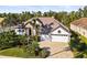 Beautiful home exterior with a well-manicured lawn, lush landscaping, and a paver driveway leading to a three-car garage at 6815 Turnberry Isle Ct, Lakewood Ranch, FL 34202