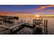 Sunset view of boat lift and dock on the water at 696 Regatta Way, Bradenton, FL 34208
