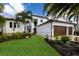 Two-story home with double garage, lush landscaping, and palm trees at 696 Regatta Way, Bradenton, FL 34208