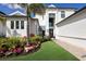 Elegant white home with a manicured lawn and vibrant flowerbeds at 696 Regatta Way, Bradenton, FL 34208
