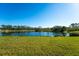 Stunning lake view from backyard, lush green grass and clear blue skies at 7228 Great Egret Blvd, Sarasota, FL 34241