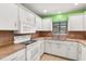 White kitchen cabinets, appliances, and brown countertops at 7505 4Th W Ave # 7505, Bradenton, FL 34209