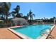 Community pool with brick deck and lounge chairs at 7628 Whitebridge Gln, University Park, FL 34201