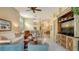 Open living area showcasing stylish furnishings, a large TV, and access to a dining area at 7741 Whitebridge Gln, University Park, FL 34201