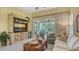 Living room features a large TV, comfy seating, and sliding glass doors leading to a screened patio at 7741 Whitebridge Gln, University Park, FL 34201