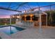 Outdoor kitchen with built-in grill, fire pit, and bar seating at 8358 Redonda Loop, Lakewood Ranch, FL 34202