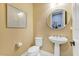 Small, updated powder room with pedestal sink and neutral color palette at 8358 Redonda Loop, Lakewood Ranch, FL 34202