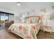 Main bedroom with floral bedding and access to a balcony at 9397 Midnight Pass Rd # 404, Sarasota, FL 34242