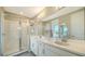 Bright bathroom with double sink vanity, framed mirrors, and a glass-enclosed shower at 10109 Milky Way Cir, Sarasota, FL 34241