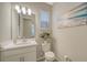 Stylish powder room with white vanity, modern fixtures, and beach-themed artwork at 10109 Milky Way Cir, Sarasota, FL 34241