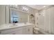 Bright bathroom featuring a double sink vanity and walk-in shower with a glass door at 10109 Milky Way Cir, Sarasota, FL 34241