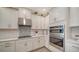 Modern kitchen with white cabinets, stainless steel appliances, and tile backsplash at 10109 Milky Way Cir, Sarasota, FL 34241