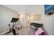 Open loft space featuring a stationary bike, piano, and television for flexible living and entertainment at 10109 Milky Way Cir, Sarasota, FL 34241