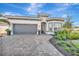 One story home with gray garage doors and a paver driveway at 10201 Beach Dune Dr, Englewood, FL 34223