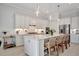 Modern white kitchen with a large island, stainless steel appliances, and white shaker cabinets at 10201 Beach Dune Dr, Englewood, FL 34223